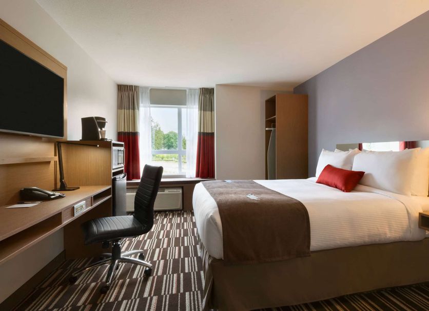 Microtel Inn & Suites by Wyndham Ladysmith Oyster Bay guest room with king bed and window desk