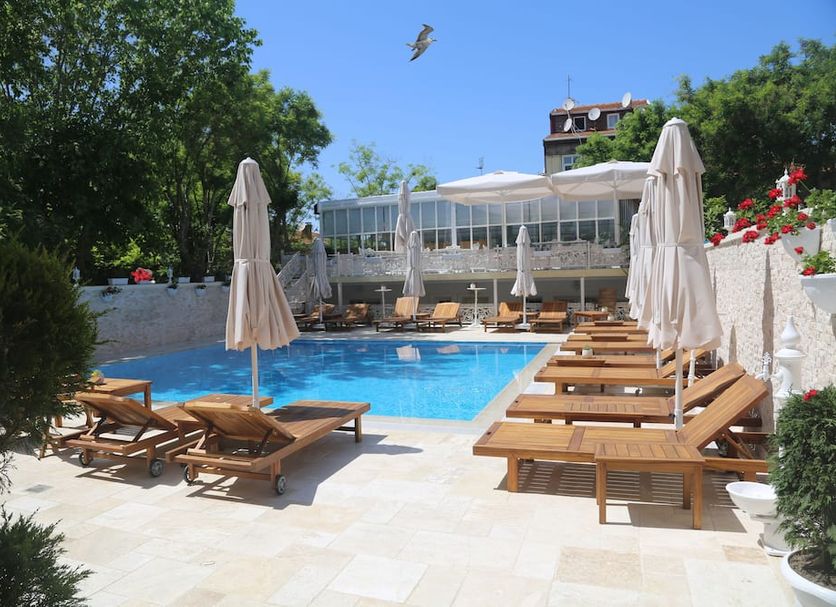 Buyukada Cankaya Hotel in Istanbul: outdoor pool with sun loungers, umbrellas, and garden terrace