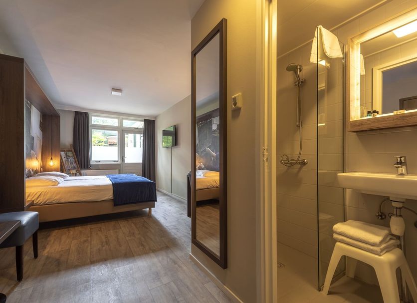 Hotel De Hoeve van Nunspeet room with bed, window view and bathroom in Nunspeet