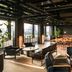 The Junto in Columbus: stylish lounge with seating, dining tables, and city-view windows