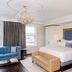 The Adelphi Hotel in Saratoga Springs room with blue sofa, king bed, chandelier and window view