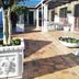 Dolphin Inn Blouberg in Cape Town courtyard with tiled patio, potted flowers, tree, and outdoor seating