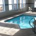 Indoor pool at Driftwood Motel in Rogers City with handrails and windows overlooking the outside