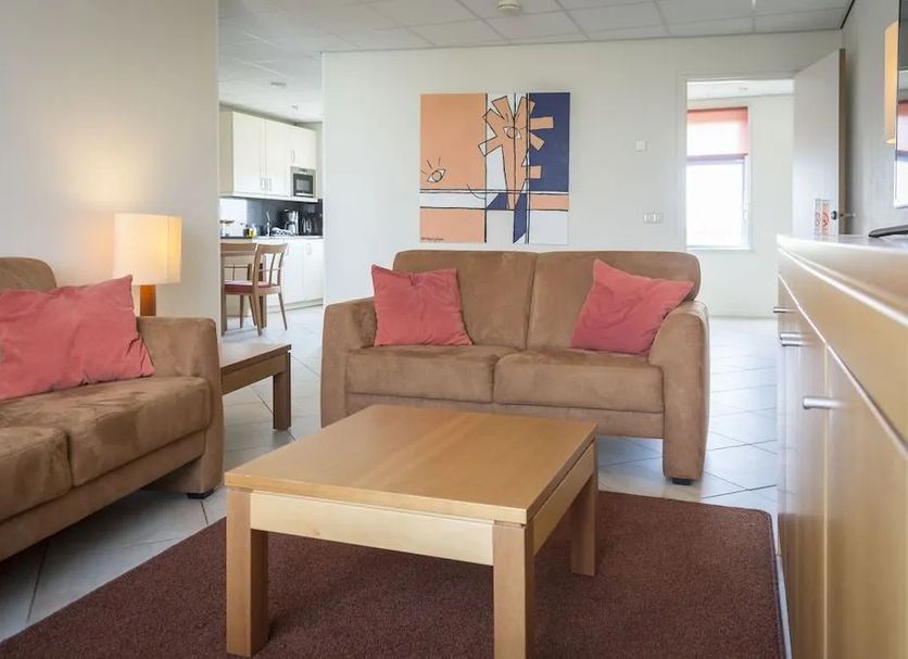 Studio's De Vlijt Texel living area with sofas, coffee table and kitchen view in De Cocksdorp