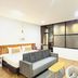 The Yak Cozy Chiang Mai room with bed, gray sofa, desk, and large window in Chiang Mai