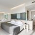 Smy Aran Blu Roma Mare room with king bed, modern bathroom vanity, and large wall mirror in Lido di Ostia