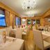Hotel Posta in Livigno dining room with mountain views through large windows and chandelier lighting
