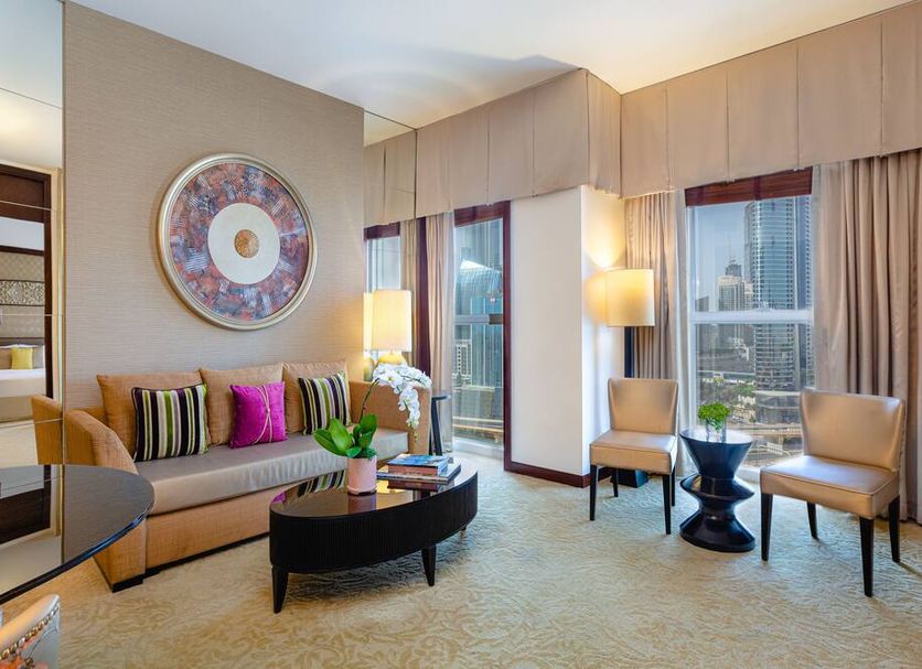 Dusit Thani Dubai luxury suite with city view, seating area, and floor-to-ceiling windows in Dubai