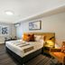 Potters Toowoomba Hotel room with queen bed, armchair and window in Toowoomba