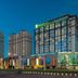 Holiday Inn & Suites Hulunbuir hotel exterior at dusk with glass facade in Hulunbuir