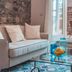Médousa Suites in Taormina living area with sofa, glass coffee table, and patio doors to a stone terrace