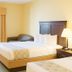 Ambassador Inn and Suites Tuscaloosa guest room with two beds, desk, and window air conditioner