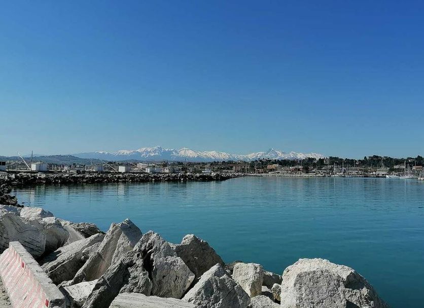 Ristorante Hotel Lucia in Giulianova with harbor view and rocky shoreline beside calm blue water
