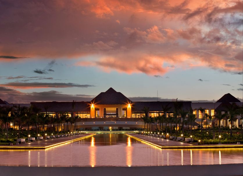 Hard Rock Hotel & Casino Punta Cana with illuminated resort pool and dramatic sunset sky in Punta Cana
