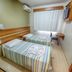 Tri Hotel Centro Chapecó guest room with two twin beds, window, desk and wall-mounted air conditioner