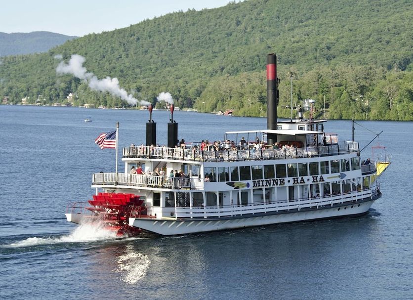 Saratoga Farmstead B&B in Saratoga Springs with a steamboat on a lake and forested hills