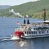 Saratoga Farmstead B&B in Saratoga Springs with a steamboat on a lake and forested hills
