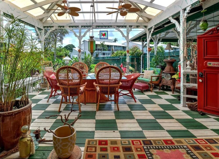 Hale Kawehi Bnb Guesthouse in Hilo: covered patio with wicker dining set, plants, and checkered floor