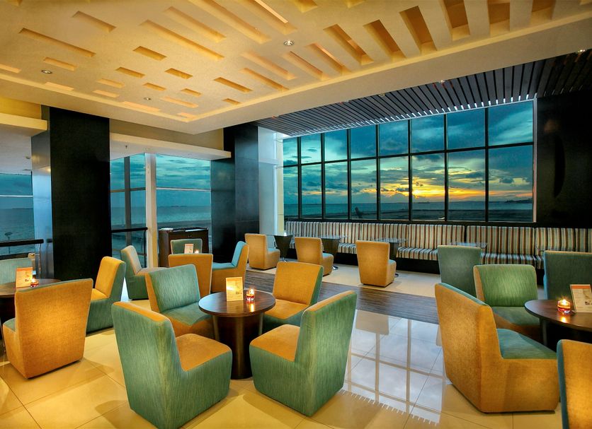Swiss-Belhotel Balikpapan lounge with large windows and sunset city views in Balikpapan