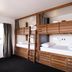 Haka House Taupo in Taupo, bunk-bed guest room with two wooden bunk beds and curtains