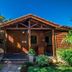 Ossanzaia Bilene Lodge wooden cabin exterior with patio seating in Bilene
