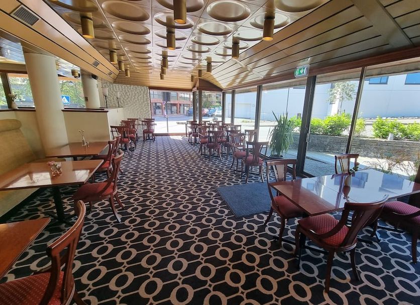 Stord Folkehøgskule Sommarhotell Leirvik dining area with large windows and patterned carpet