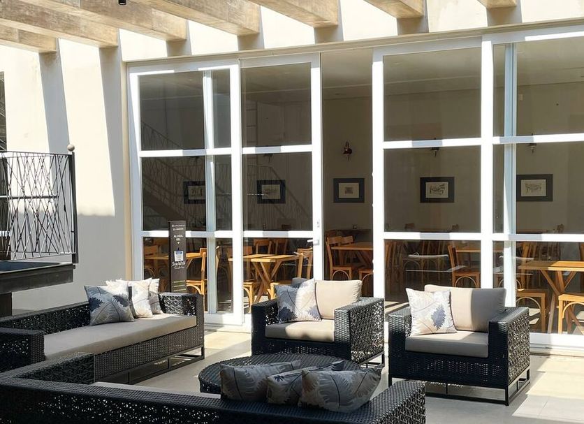 Pousada Villa Alferes patio with wicker seating outside glass doors in Tiradentes