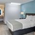 SureStay Plus by Best Western Asheboro guest room with king bed, bedside lamps and blue accent wall