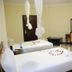 Asinuara Hotel Bahir Dar room with two twin beds, mosquito nets, desk, chair and wall-mounted TV