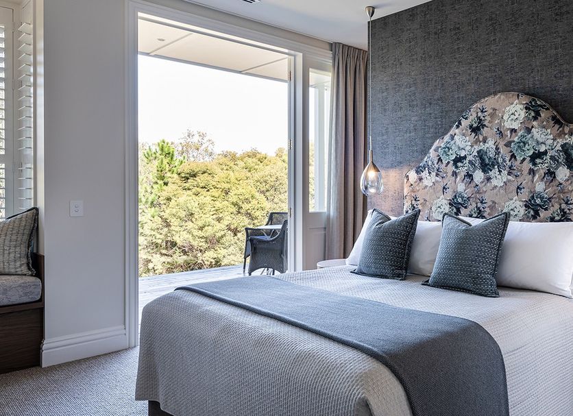 Spicers Clovelly Estate in Montville bedroom with floral headboard, balcony view and ensuite doorway
