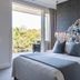 Spicers Clovelly Estate in Montville bedroom with floral headboard, balcony view and ensuite doorway