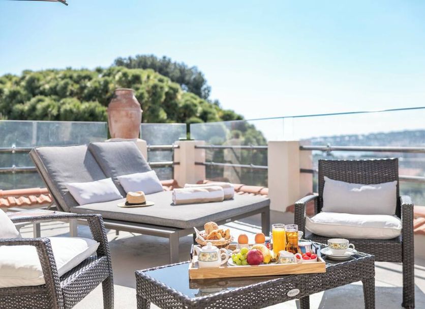 Hotel Mas Djoliba, Antibes: rooftop terrace with lounge chairs, breakfast tray, and sea view