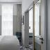 Victory House London guest room with bed, tall window, curtains, and patterned floor in London