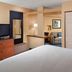 Fairfield Inn & Suites by Marriott Clarksville guest room with bed, TV, closet, and seating area