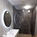 7th Mill apartments Kranj bathroom with walk-in shower, oval mirror, wall sink and wood bench