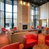 Courtyard by Marriott Kansas City East/Blue Springs lobby with red chairs, fireplace and tall windows in Blue Springs