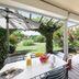 Covered patio at Club Belambra Le Vidourle in Le Grau-du-Roi with table, chairs and garden view