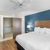Baymont by Wyndham Arlington At Six Flags Dr guest room with king bed, blue accent wall and open closet