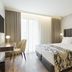 Acta The Avenue in Porto features a modern guest room with a king bed, desk, and tall window drapes.