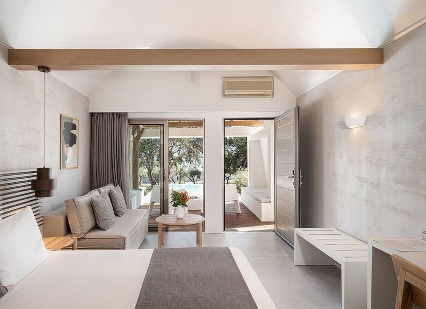 Kakkos Bay Hotel And Bungalows room with bed, sofa, and patio doors in Koutsounára