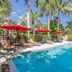 Casa Grandview in West Palm Beach: tropical courtyard pool with loungers and red umbrellas