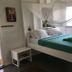 Green Roof Inn in Carriacou guest room with bed, mosquito net, and teal bedding