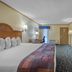 SureStay by Best Western Kansas City Country Inn North guest room with king bed, TV and desk