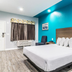 Scottish Inns & Suites - Kingwood room in Humble with king bed and bright turquoise accent wall