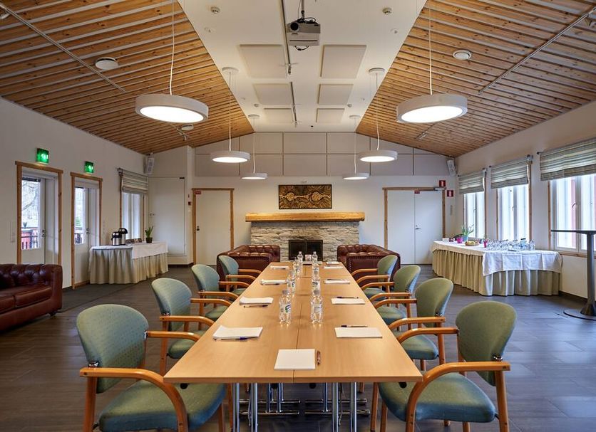 Apartments in Porvoo meeting room with long conference table, chairs, and stone fireplace in Porvoo