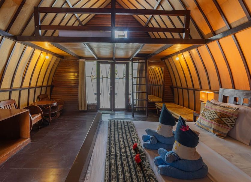 Omah Gili Hotel in Pemenang: cozy loft-style room with bed, desk, and French doors