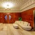 Arabella Residence Cairo lounge with curved cream sofa, red armchairs, ornate ceiling and wood-paneled walls