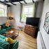 The Lawrence, Burnley: stylish lounge with teal sofas, coffee table, TV and windows