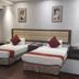 The Platinum Hotel Hyderabad twin room with two beds, bedside tables, wall art and curtains