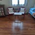 Il Riposo del Guerriero Guesthouse in Genoa room with two chairs, small table, bed and wood floor